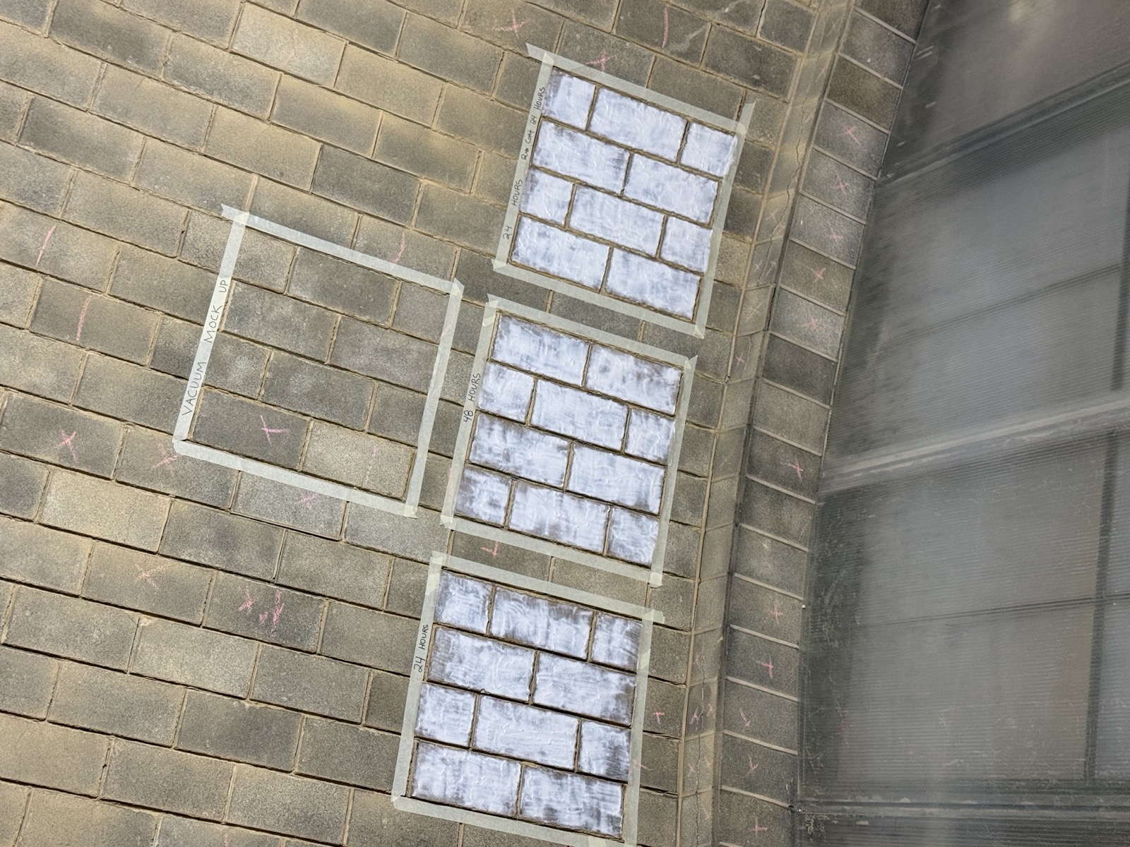 Four taped cleaning test panels on the Akoustolith tile wall at Buffalo Central Terminal
