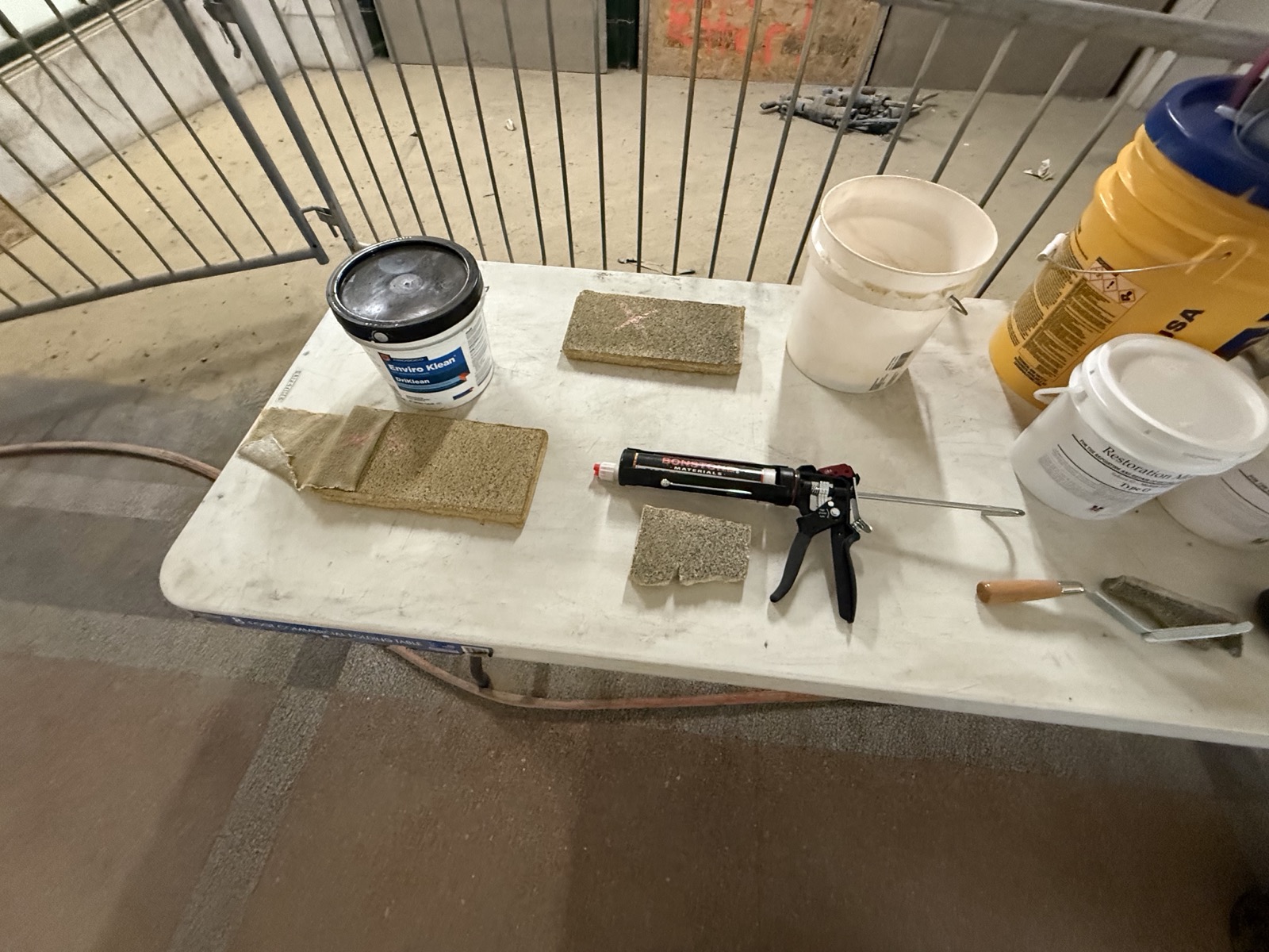 Work table with removed Akoustolith tiles, epoxy, and mortar at Buffalo Central Terminal